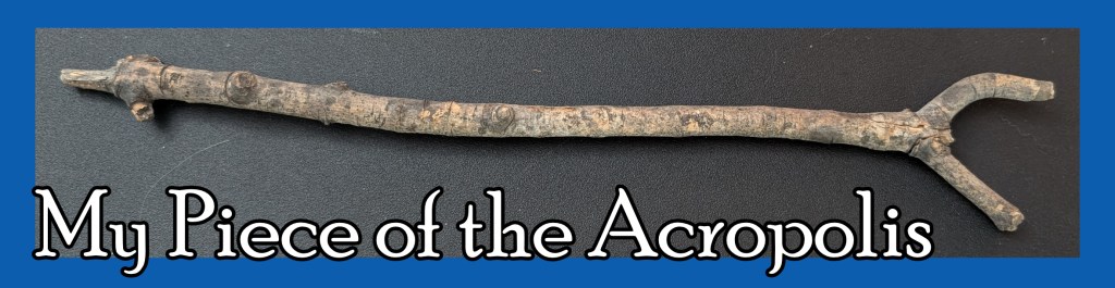 A picture of a small stick with two prongs at the end. The text says "My Piece of the Acropolis."