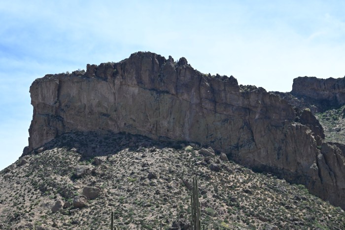 a desert mountain juts into a blue sky